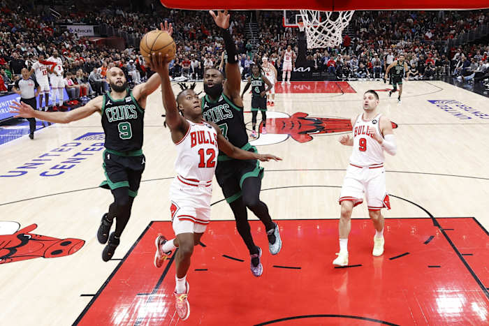 Chicago Bulls guard Ayo Dosunmu (12) goes to the basket against Boston Celtics guard Jaylen Brown (7) during the second half at United Center.